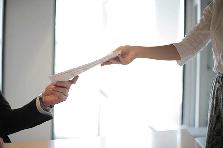 Secretary handing a document to a businessman