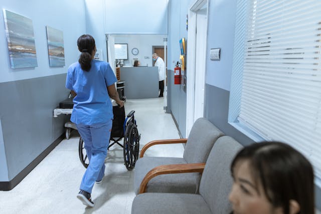Nurse pushing a wheelchair in a hospital hallway